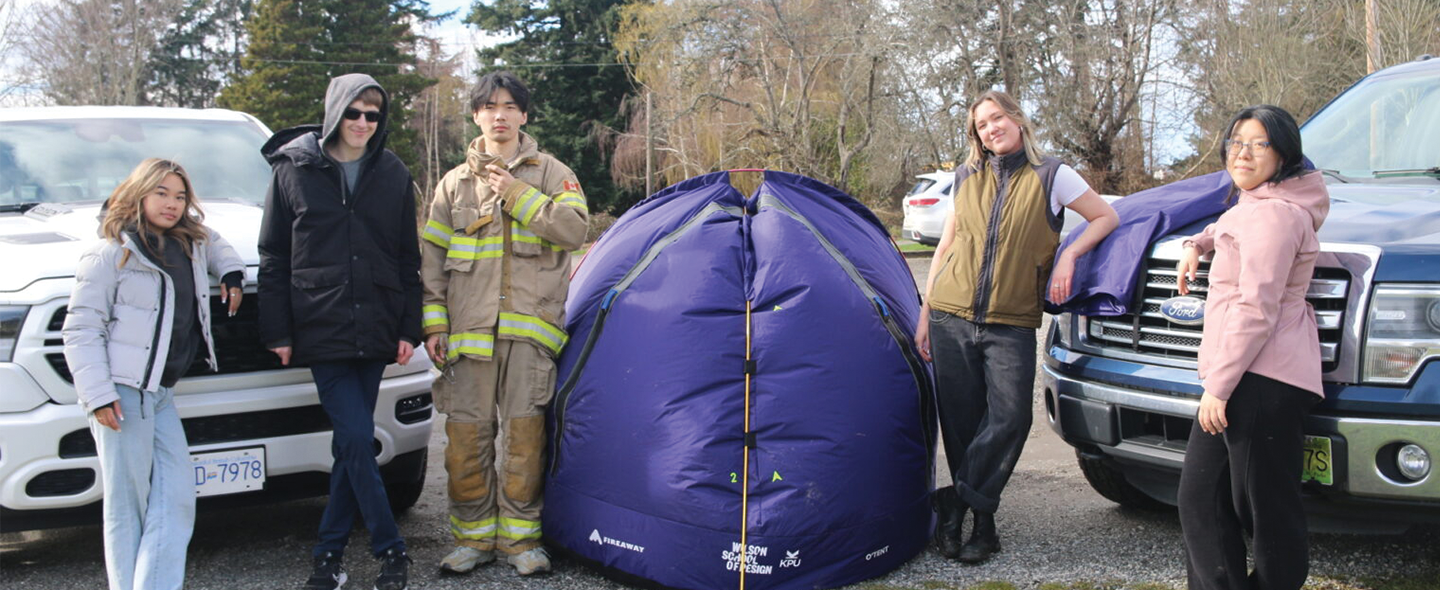 Students standing next to their tent design