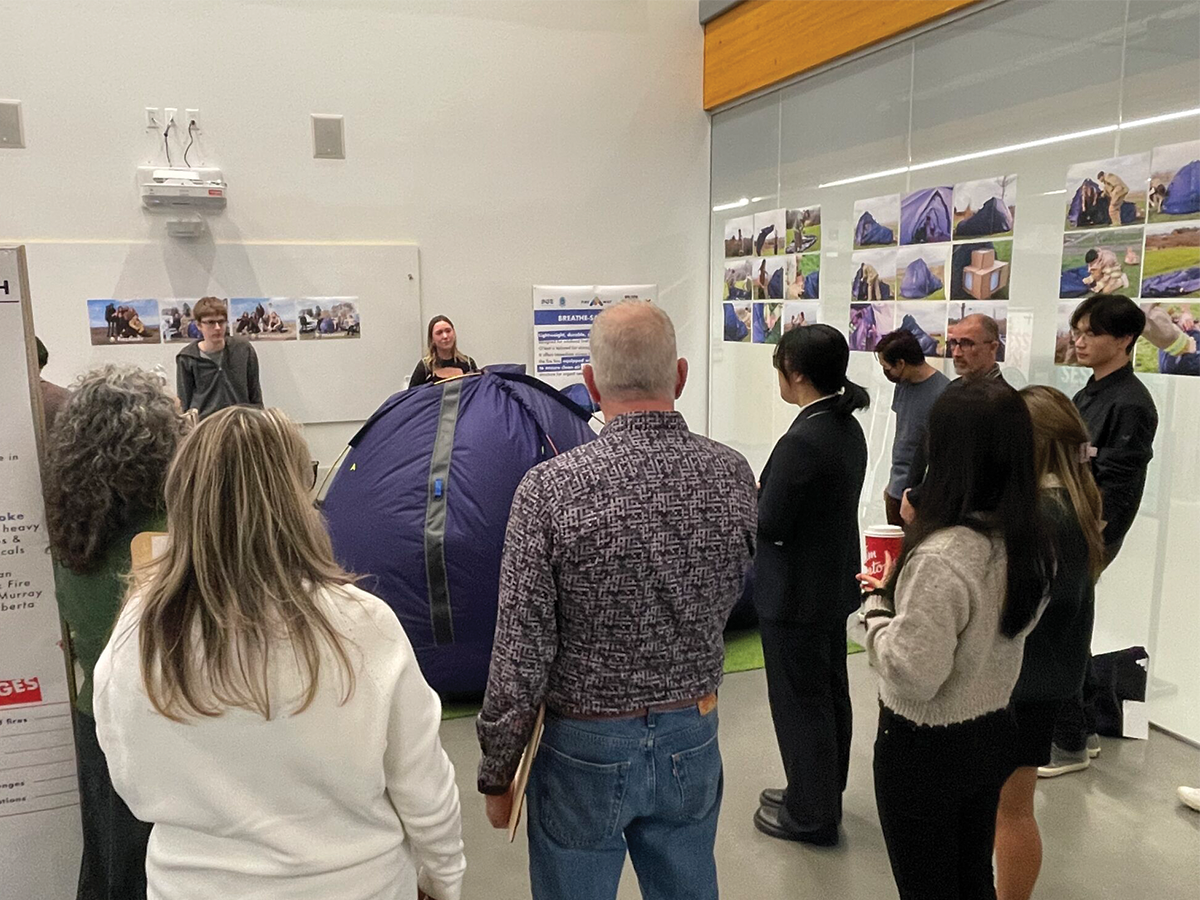 Students presenting tent design to a crowd