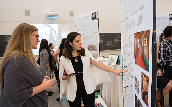 Two people talking about Grad Show Display