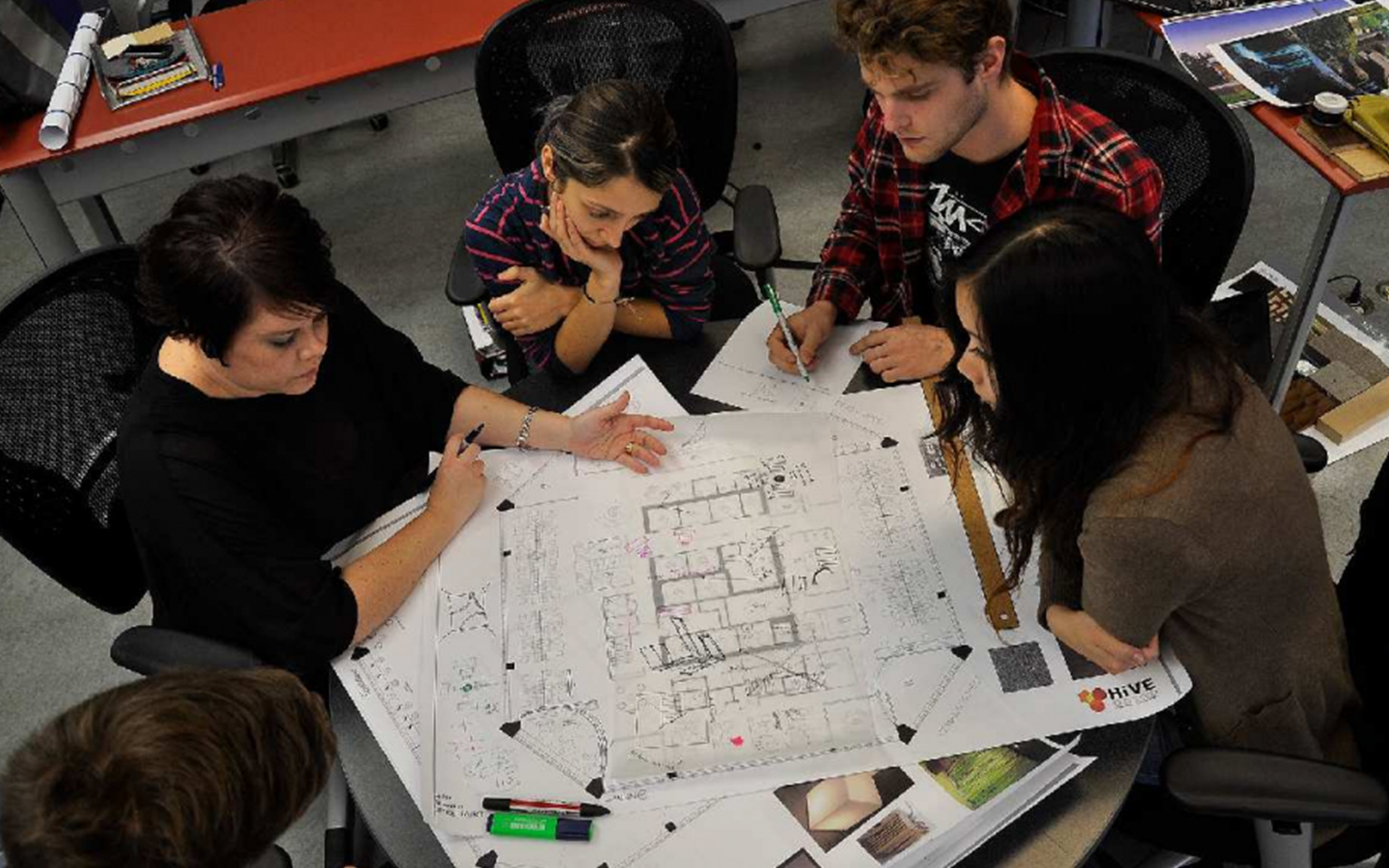 Paola with Interior Design students working on a blueprint