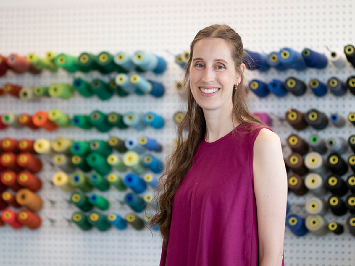 Heather in front of sewing studio wall with threads